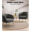 Two charcoal boucle tub chairs with gold legs facing each other, gold side table on jute rug, 
