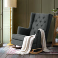 Charcoal tufted wingback rocking chair with white throw, yellow floor lamp and green panelled wall in warm lifestyle room