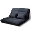 Charcoal suede floor lounger in upright seat position with two matching scatter pillows on white background