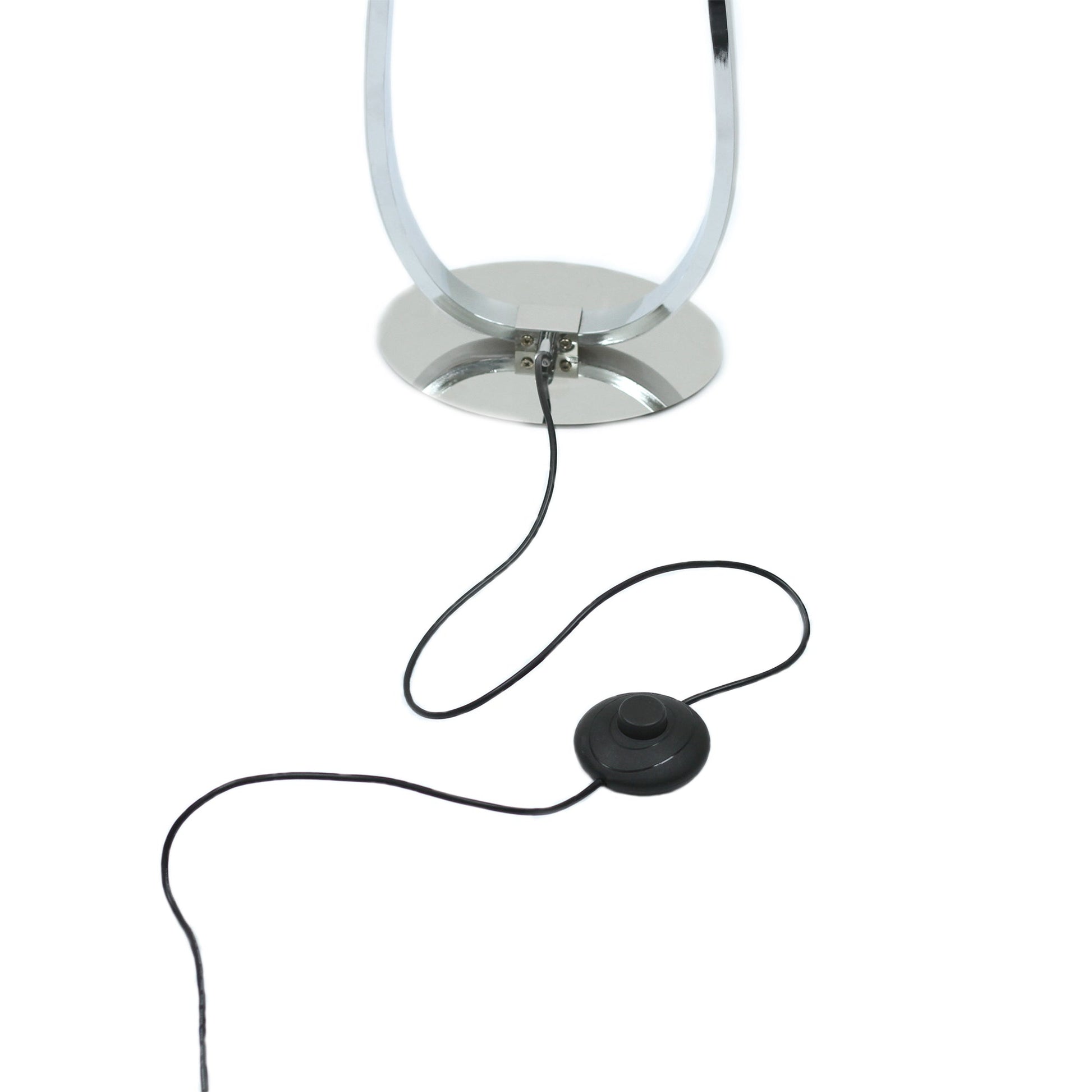 Close-up of chrome oval base with black power cord and round foot dimmer switch below