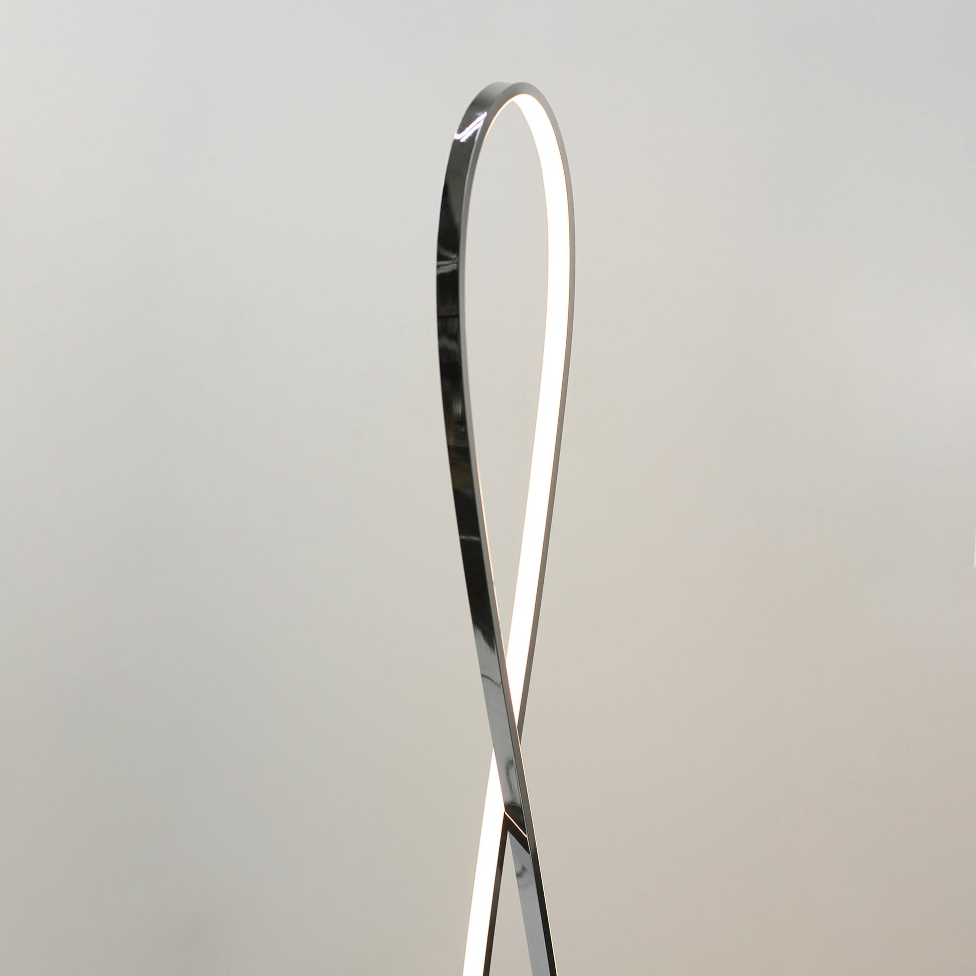 Close-up of upper teardrop loop top on grey background, dark chrome exterior with white LED strip along inner edge