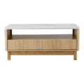Coffee table front view on white background, white marble top, open shelf and two fluted drawers, round wood legs