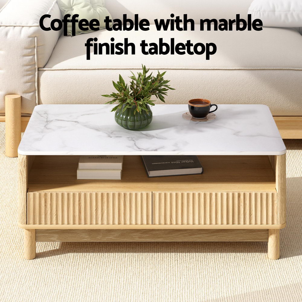 Coffee table with plant and coffee cup on marble top, books on shelf, text: Coffee table with marble finish tabletop
