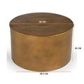Oval wood-top table on a black metal frame with two dark navy fabric cube ottomans tucked underneath, angle view on white