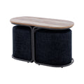 Oval wood-top coffee table and ottoman set in a living room in front of a cream sofa, two navy fabric ottomans seated under