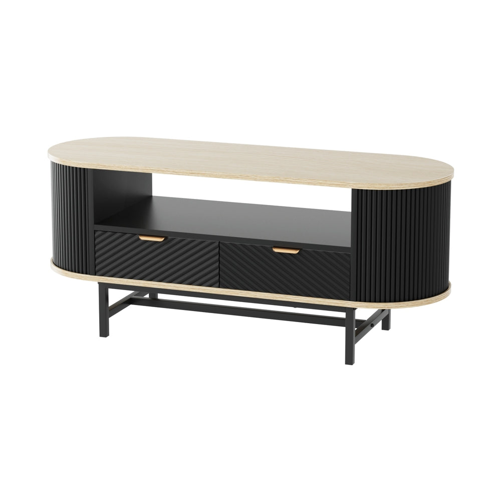 Oval coffee table with oak-effect top, black fluted side panels, two diagonal-pattern drawers, open shelf, and black metal