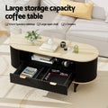 Oval fluted coffee table with oak top, both drawers open showing interior 30x28x12cm with books and accessories inside, in a