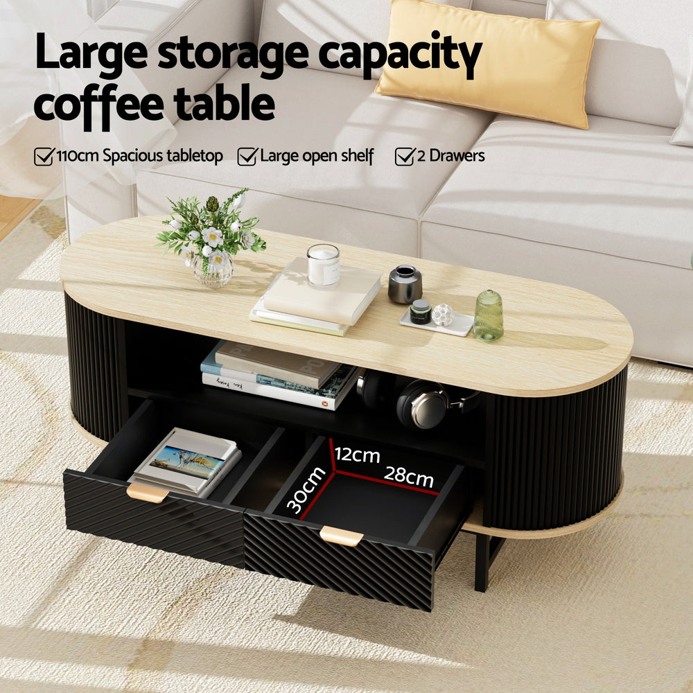 Oval fluted coffee table with oak top, both drawers open showing interior 30x28x12cm with books and accessories inside, in a