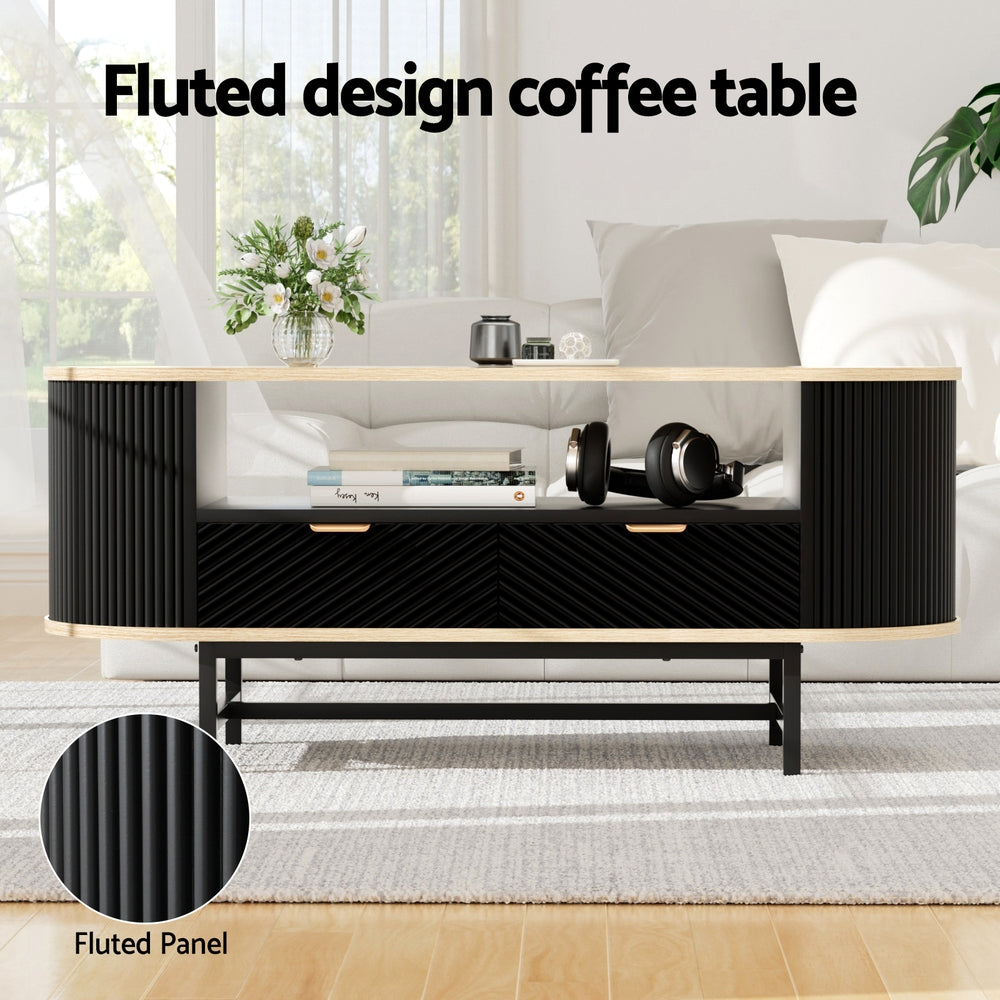 Oval fluted coffee table with oak top in a white living room with flowers, books and headphones on table, fluted panel