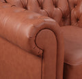 Tan cognac Chesterfield sofa rolled scroll arm close-up showing PU leather tufting and rounded arm end