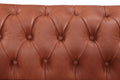 Tan cognac Chesterfield sofa deep button-tufted backrest close-up showing diamond pattern with round buttons