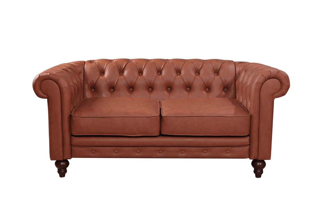 Tan cognac Chesterfield 2-seat sofa in classic room with arched window, rugs and framed prints on wall