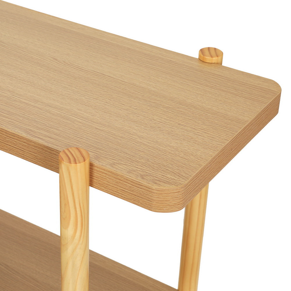 Close-up of natural oak console top corner showing rounded edge, round leg joint, and visible wooden peg detail