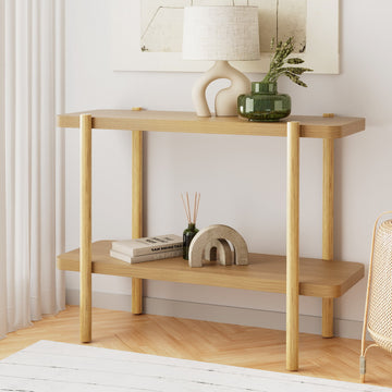Two-shelf oak console table with four round legs in room, lamp and vase on top, books and arches on lower shelf