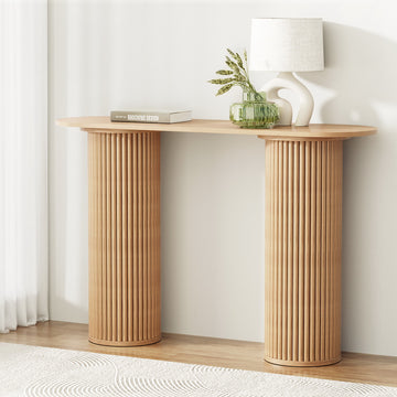 Console table with natural oak oval top and two large cylindrical fluted column legs, styled with lamp and vase in room