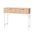 Console table with natural oak fluted two-drawer front and white metal X-frame legs, three-quarter angle on white background