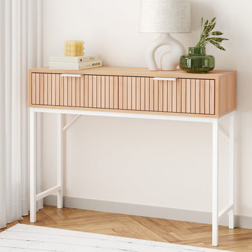 Console table with fluted oak drawer front, white X-frame metal legs, styled with books and green glass vase in room