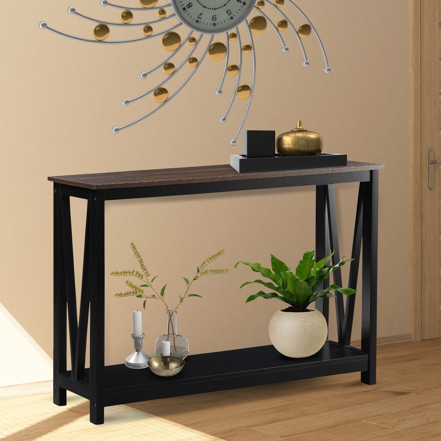 Walnut-top black X-frame console table in warm-toned room, gold and black decor on top, plants and candles on lower shelf