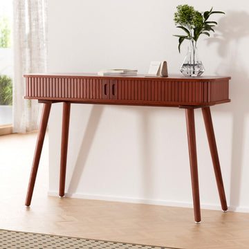 Console table in walnut finish with fluted drawer front and angled tapered legs, styled with books and glass vase in room