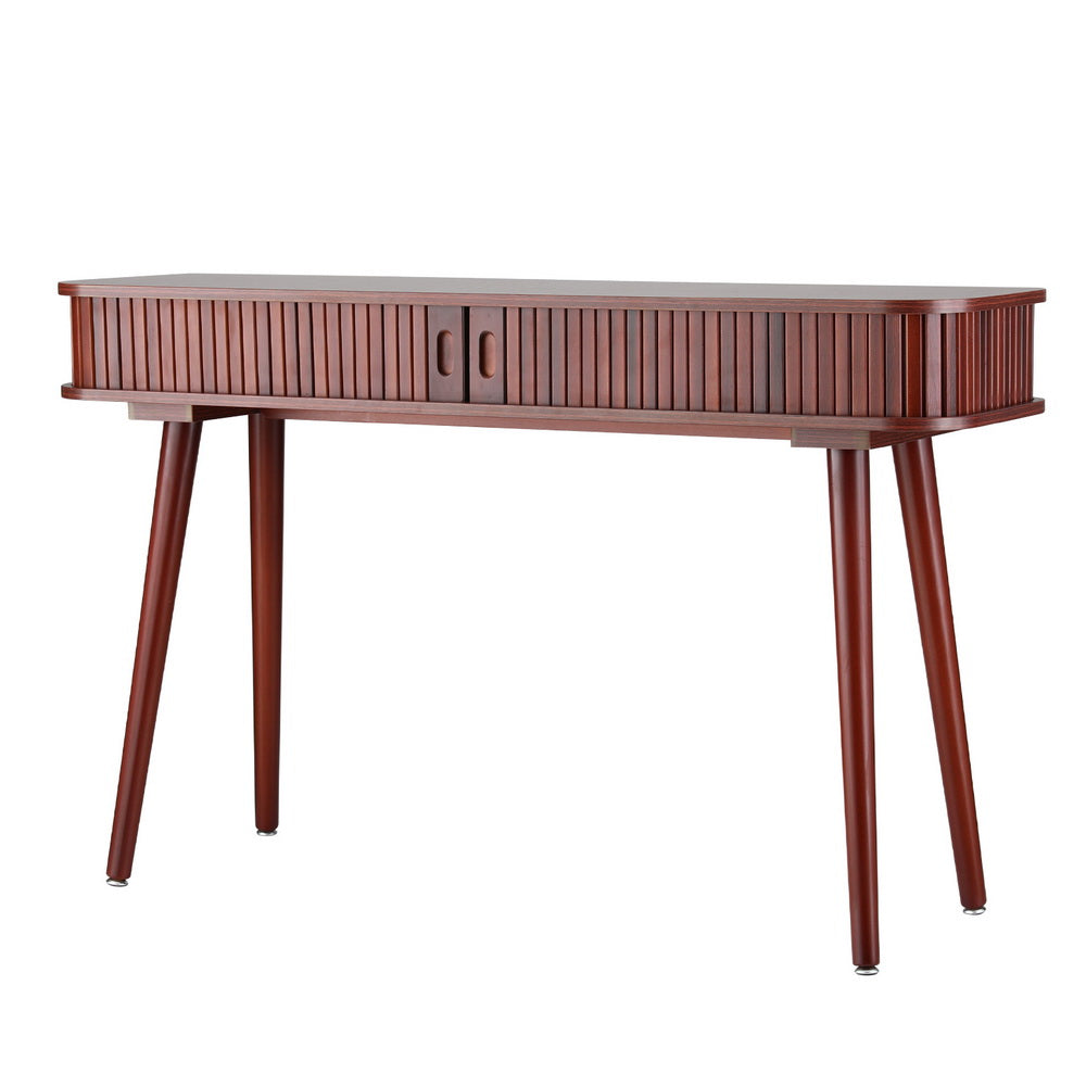 Console table in walnut finish with fluted drawer front and angled tapered legs, styled with books and glass vase in room