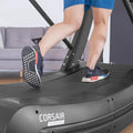 Running shoes on Corsair FreeRun 105 ribbed treadmill deck showing tread grip