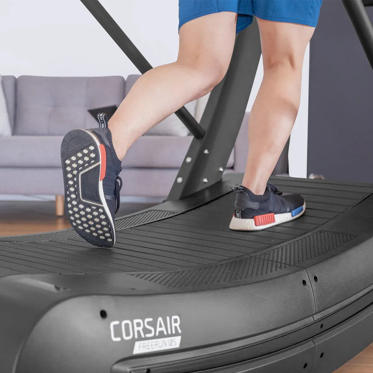 Running shoes on Corsair FreeRun 105 ribbed treadmill deck showing tread grip