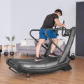 Man using FreeRun 105 treadmill with kettlebells and couch visible in home gym space