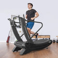 Man running on Corsair FreeRun 105 in home gym with shelving and gym equipment in background
