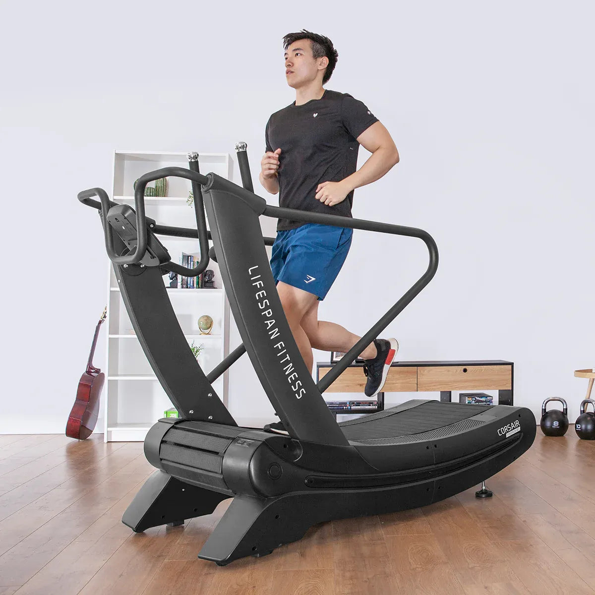Man running on Corsair FreeRun 105 in home gym with shelving and gym equipment in background