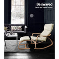 Cream bentwood rocking chair and footrest in dark living room with dark sofa, white coffee table, text: Be swayed