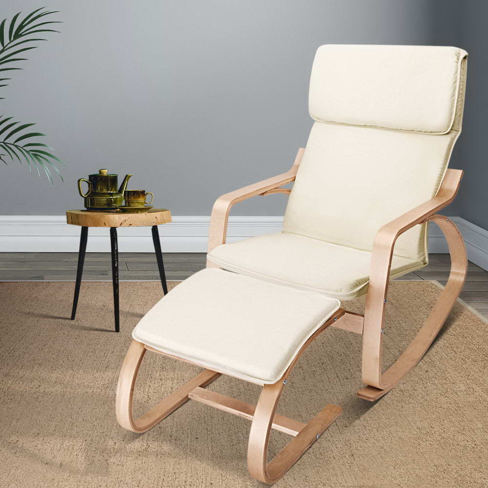 Cream fabric cushioned bentwood rocking chair with matching footrest in grey room beside wooden stool with gold tea set