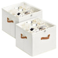 Two cream fabric shoe storage boxes with clear zipper lids and tan leather handles loaded with shoes on white background