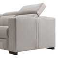 Close-up of cream leather recliner sofa end section side panel with adjustable headrest raised at angle