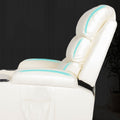 Close-up of cream PU leather recliner backrest and seat with teal glowing massage indicators along seams, dark background