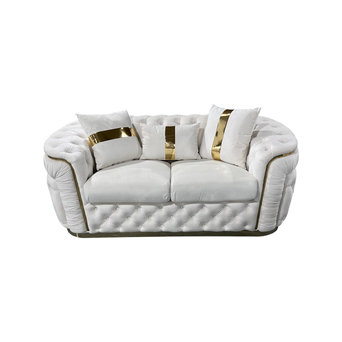 Cream velvet chesterfield 2-seater loveseat with gold-striped pillows and button tufting on white background