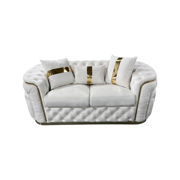 Cream velvet chesterfield 2-seater loveseat with gold-striped pillows and button tufting on white background