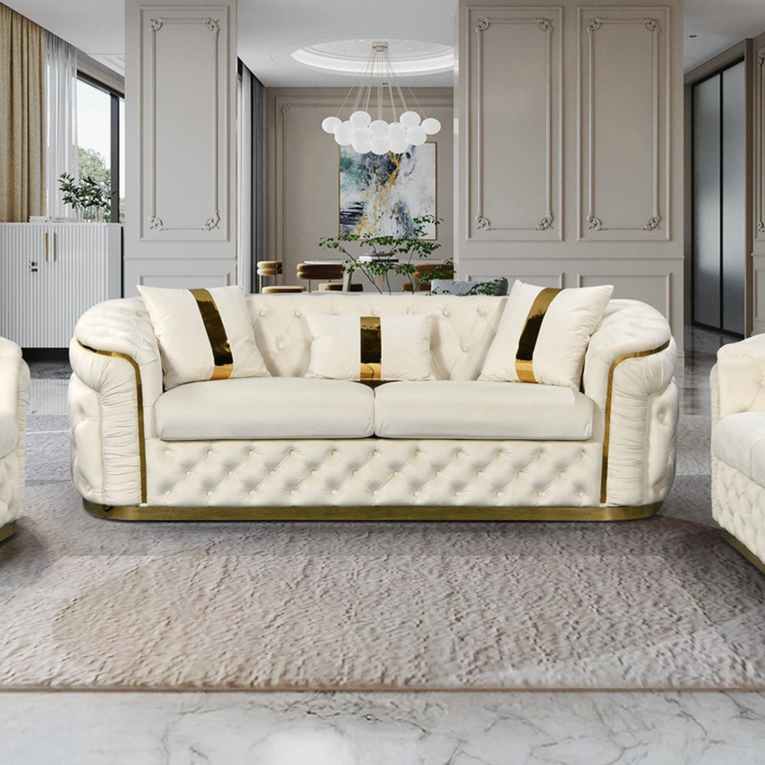 Cream velvet chesterfield 3-seater sofa with gold accents and throw pillows in opulent white living room