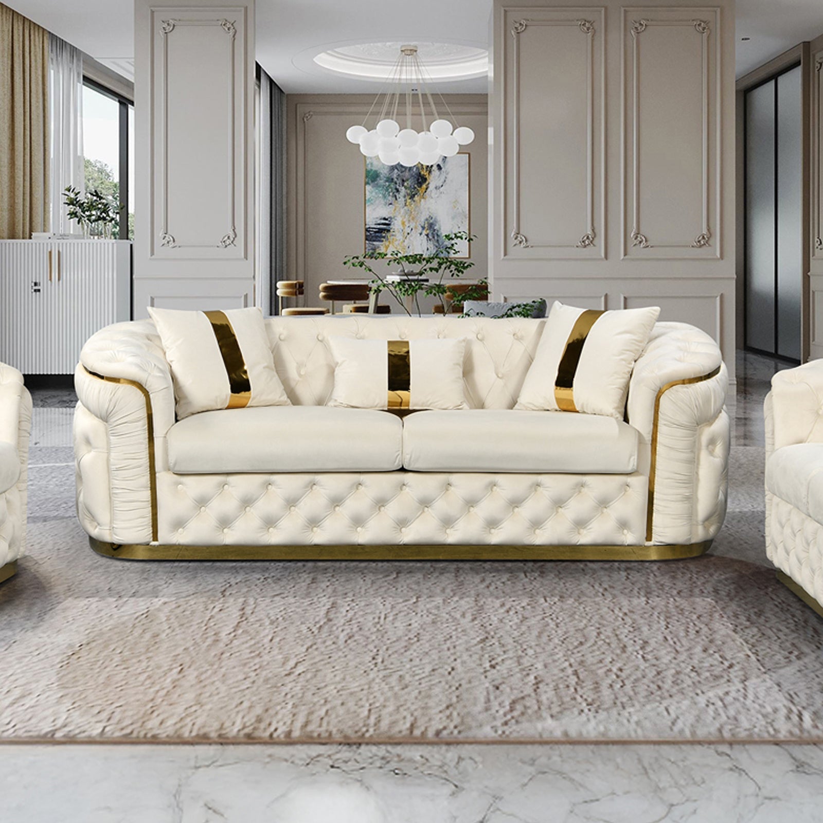 Cream velvet chesterfield 3-seater sofa with gold accents and throw pillows in opulent white living room