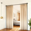 Black curtain rod frame L-shape corner config in bedroom corridor with beige curtains open showing bed and wardrobe behind