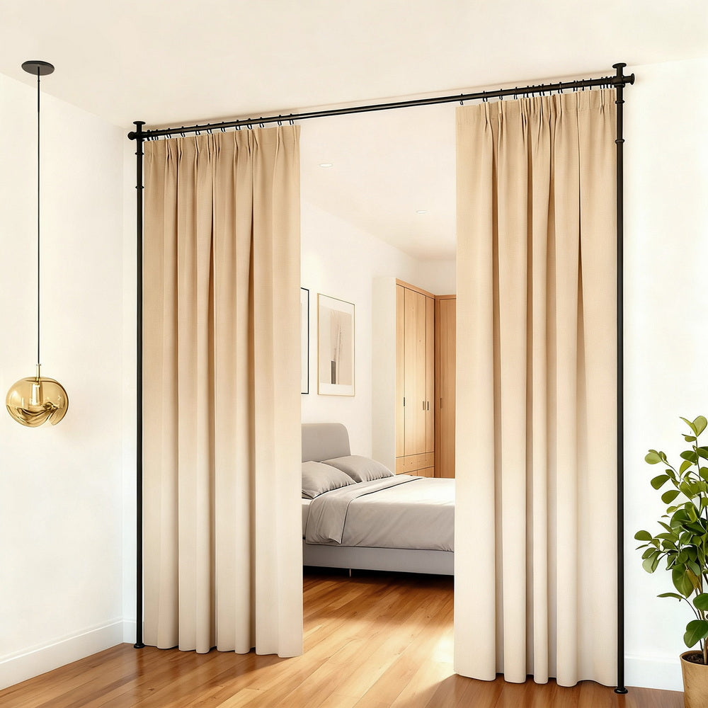 Black curtain rod frame L-shape corner config in bedroom corridor with beige curtains open showing bed and wardrobe behind