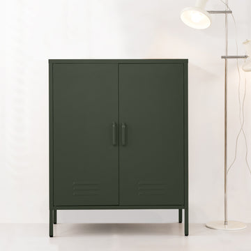 Dark green two-door metal locker cabinet with bar handles and louvre vents beside chrome floor lamp
