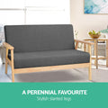 Dark grey fabric two-seater sofa in lifestyle dining room, text: A Perennial Favourite, Stylish slanted legs