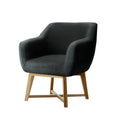 Dark charcoal fabric tub armchair with curved seat and natural wood legs with cross-brace, angle view on white background