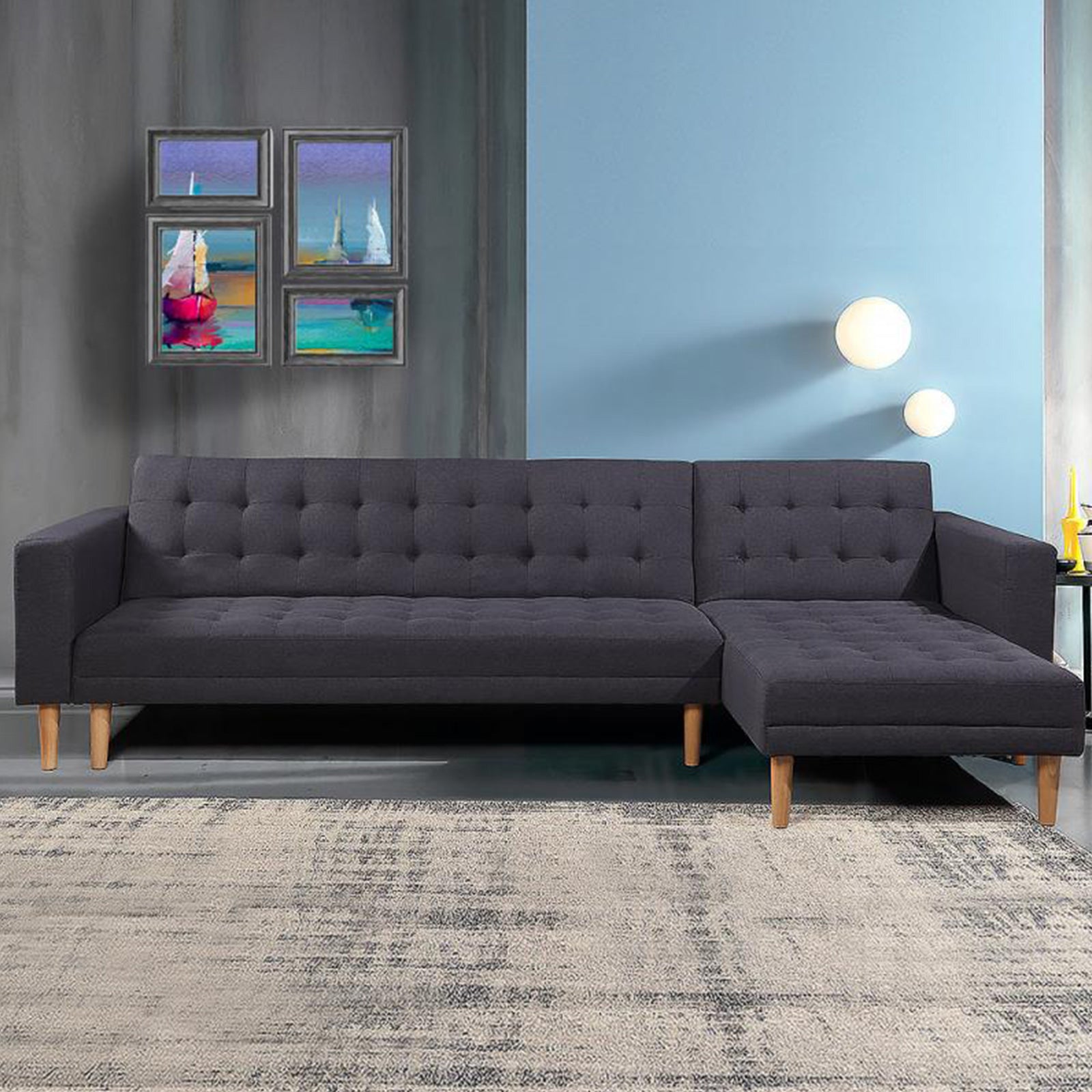 Dark charcoal grey L-shape sofa in living room with blue wall colorful artworks and wall sconces