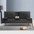 Dark grey fabric sofa bed with cup holder tray open holding two coffee cups in modern living room