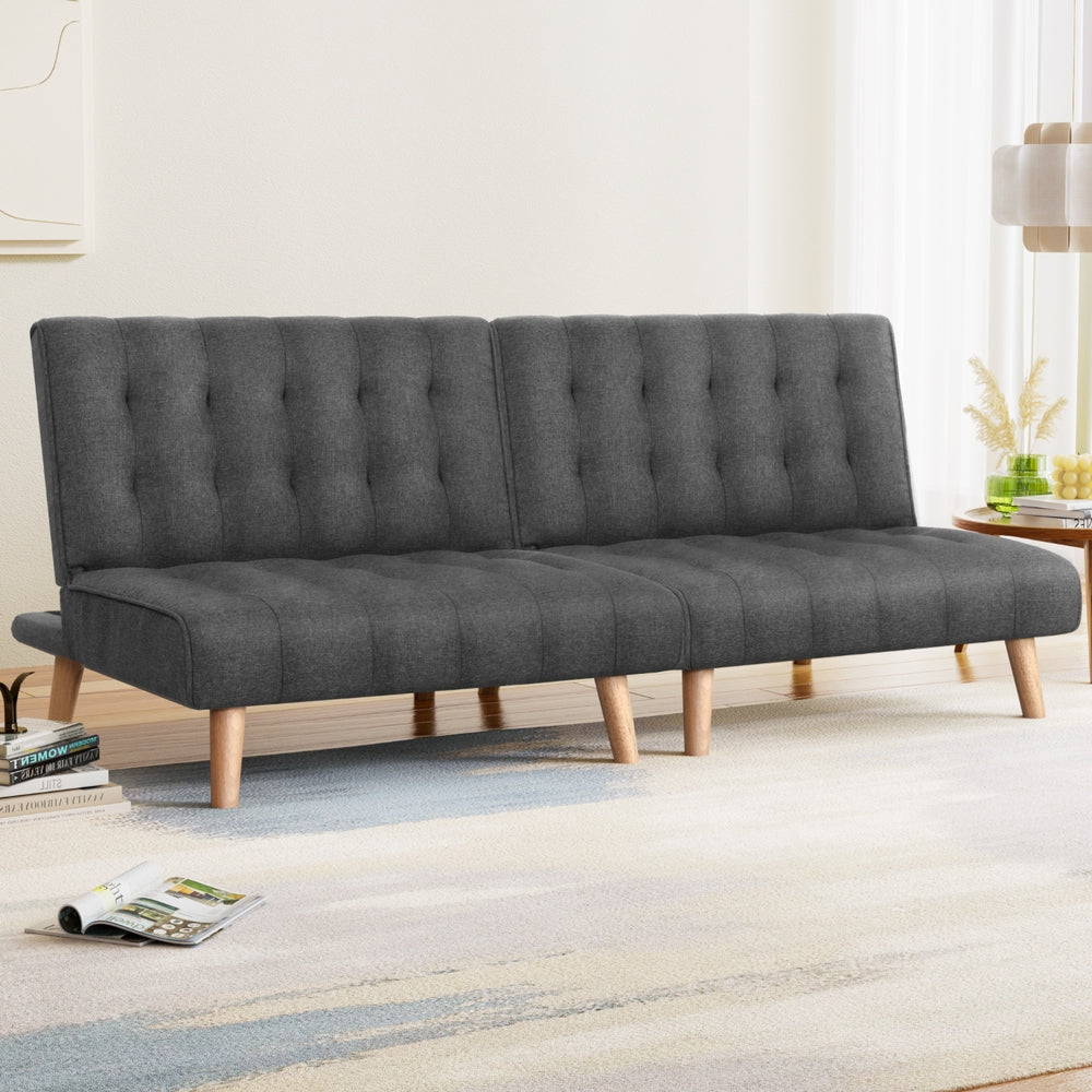 Two dark grey tufted armless sofa bed units placed side by side on white background front view