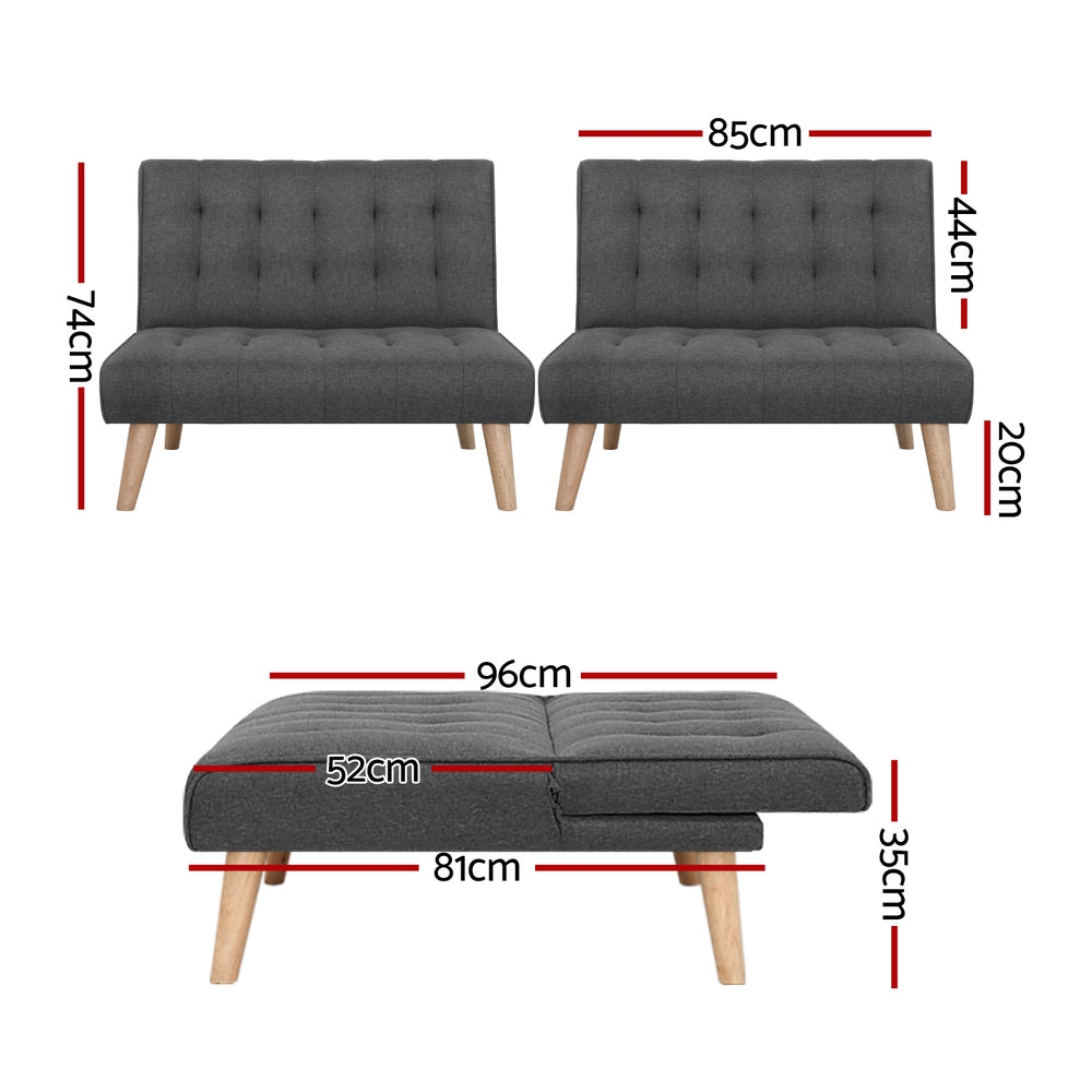 Dark grey tufted armless sofa bed with wooden legs viewed from front on white background