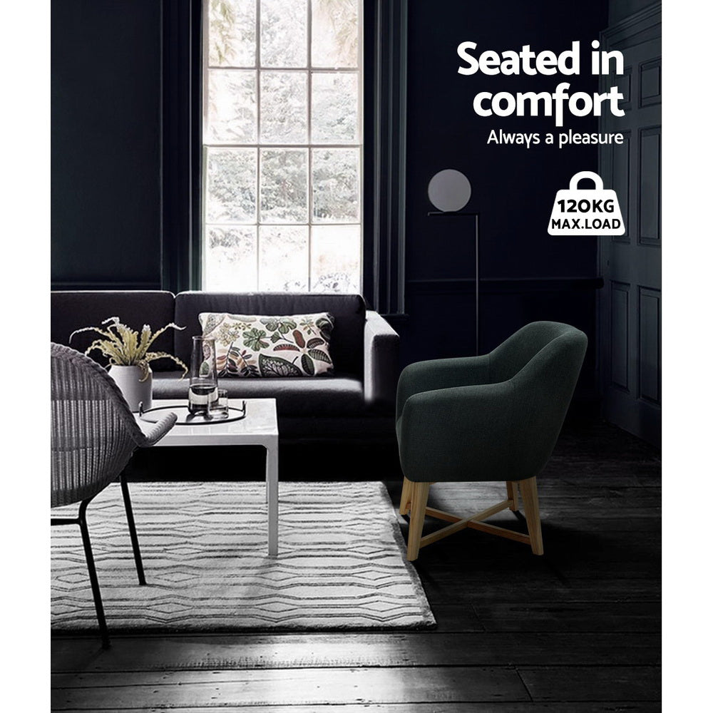 Dark charcoal tub armchair in dark living room with sofa, white coffee table, 120KG max load badge, text: Seated in comfort