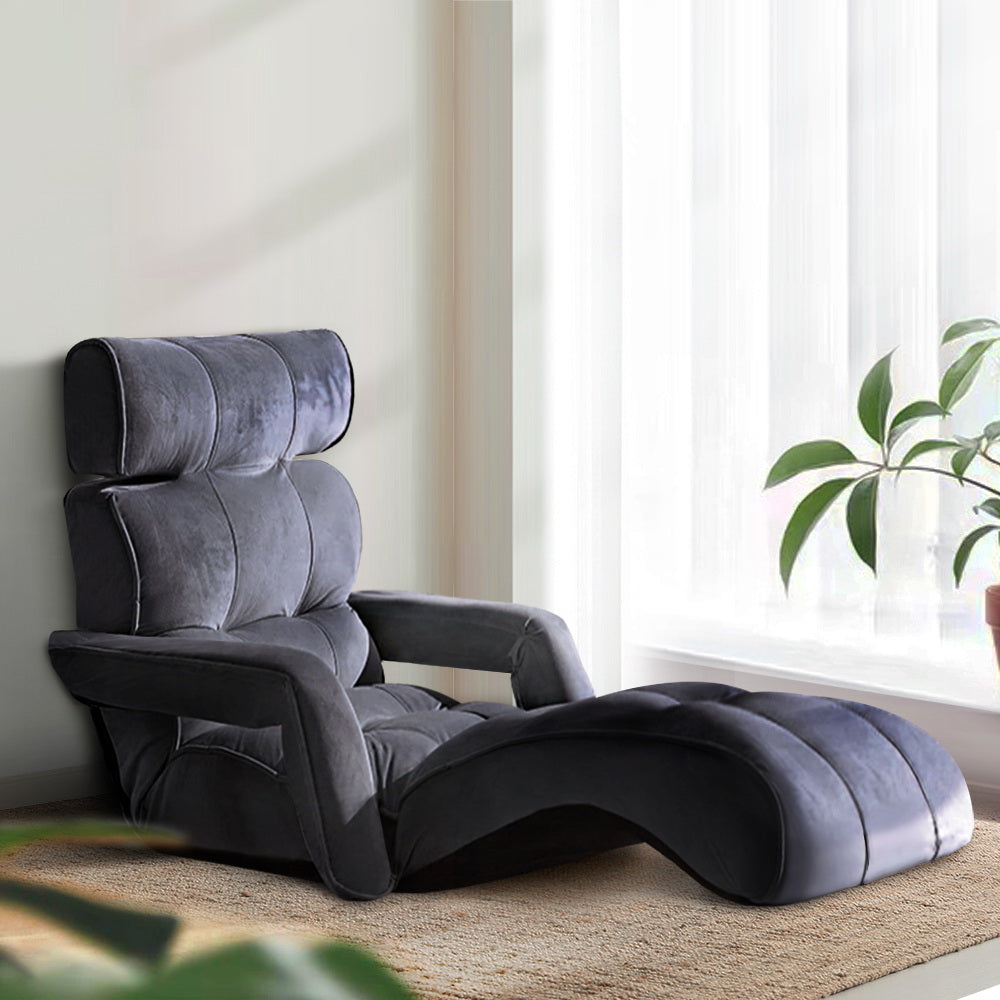 Dark grey velvet floor lounger with adjustable backrest and curved footrest in upright position, white wall lifestyle setting