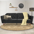 Dark grey velvet tufted sofa bed with throw blanket styled in cream living room with walnut and gold-tipped legs
